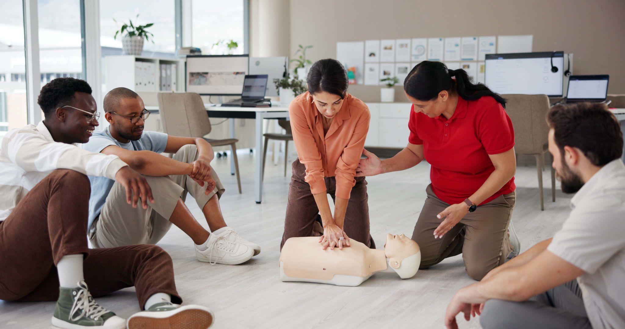 Learners practising CPR and AED skills during an Emergency First Aid at Work training course.